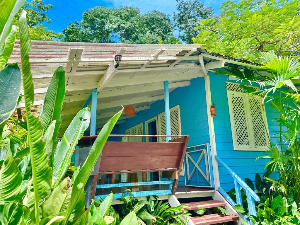 a blue house with a bench in front of it at Ita Ita Casitas Playa Punta Uva in Punta Uva