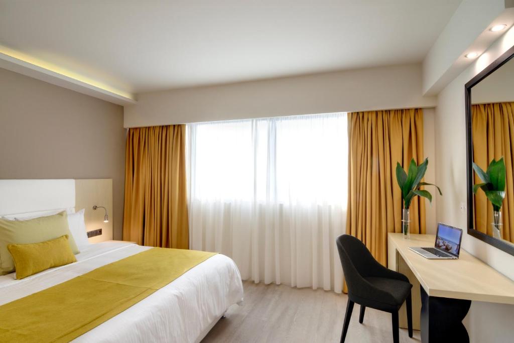Postel nebo postele na pokoji v ubytování Athens Avenue Hotel