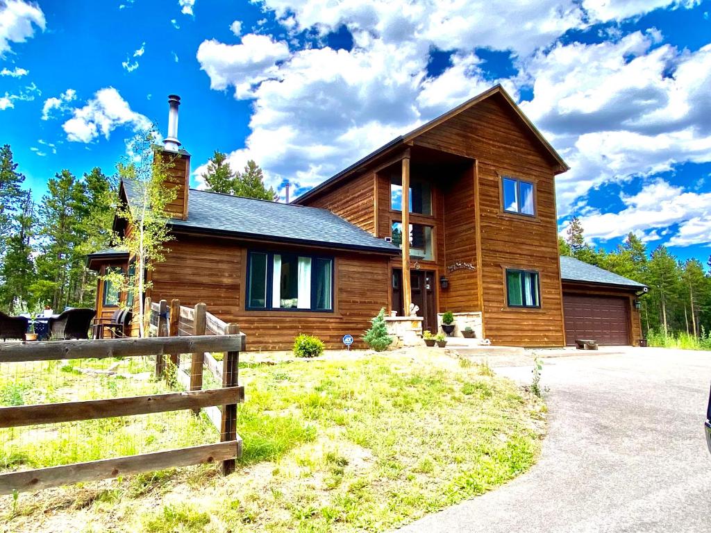 a wooden house with a fence in front of it at Echo Hills Mountain Lodge - Evergreen Mountain Top Retreat - 15 minutes to SKI!! in Evergreen