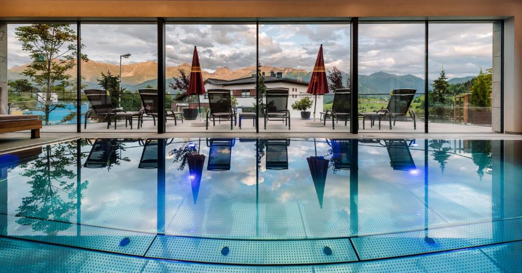 a large swimming pool with chairs and umbrellas at Hotel Sedona Lodge in Fiss