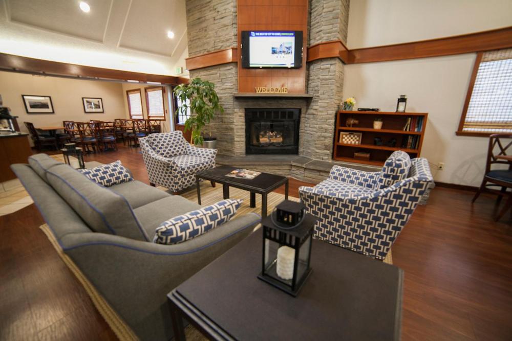ein Wohnzimmer mit Sofas und einem Kamin in der Unterkunft New Haven Village Suites in New Haven