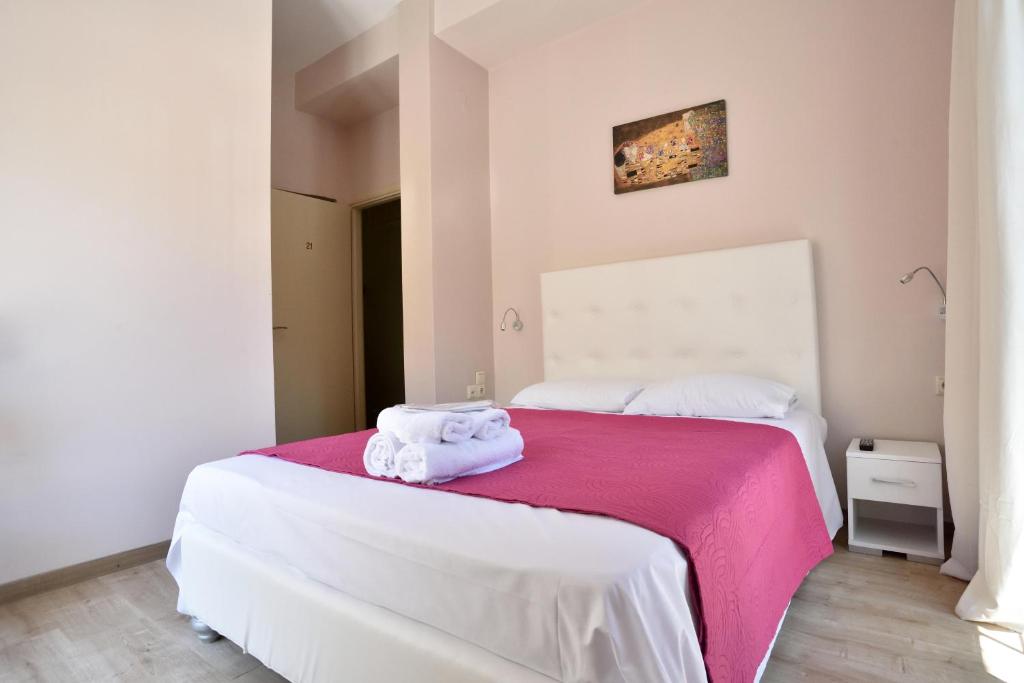 ナフプリオにあるAsimoni Pensionのベッドルーム1室(ベッド1台、タオル2枚付)