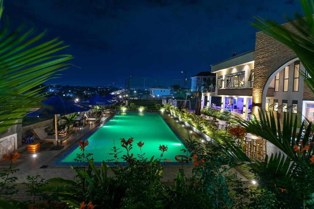 a swimming pool lit up at night at Equinox Vacation Apartments in Bulambiro