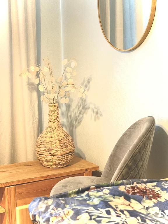 a vase of flowers sitting on a table with a mirror at Midnight Sun center apartments in Sodankylä