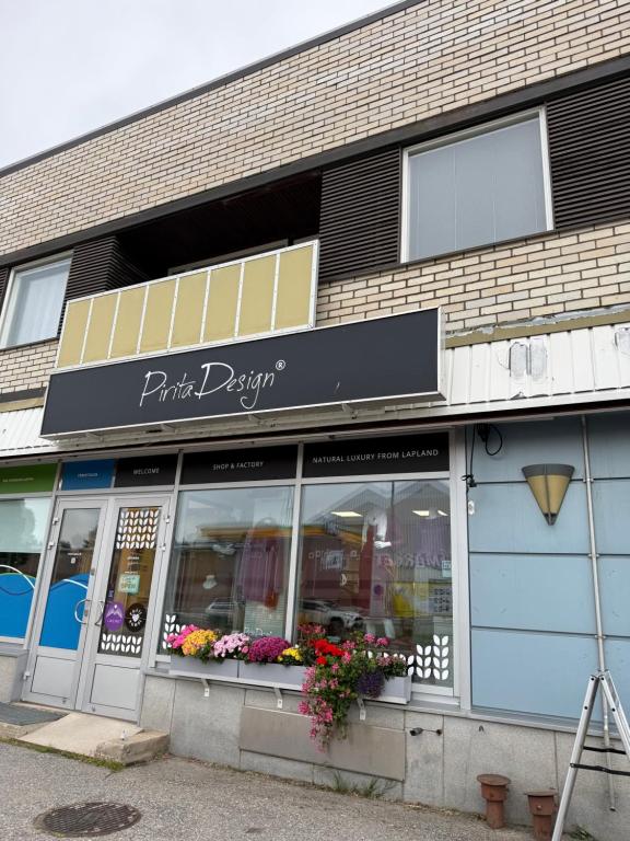 a store front of a building with flowers in the windows at Midnight Sun center apartments in Sodankylä