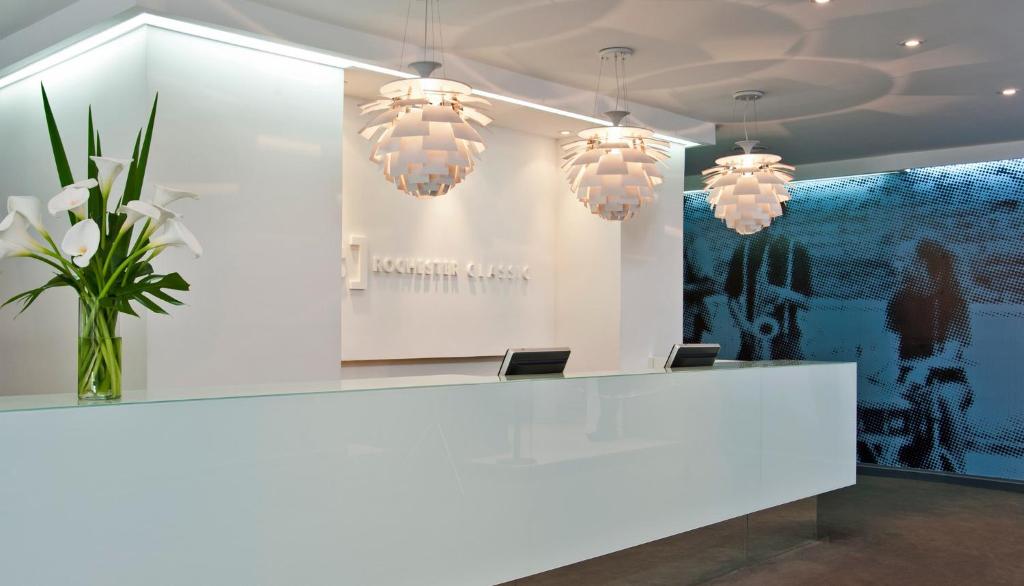 a lobby with a white counter and chandeliers at Rochester Hotel Classic in Buenos Aires