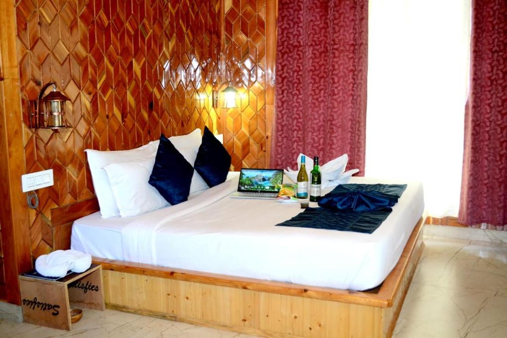 une chambre avec un lit avec un ordinateur portable dessus dans l'établissement Hotel Oscar Manali, à Manali