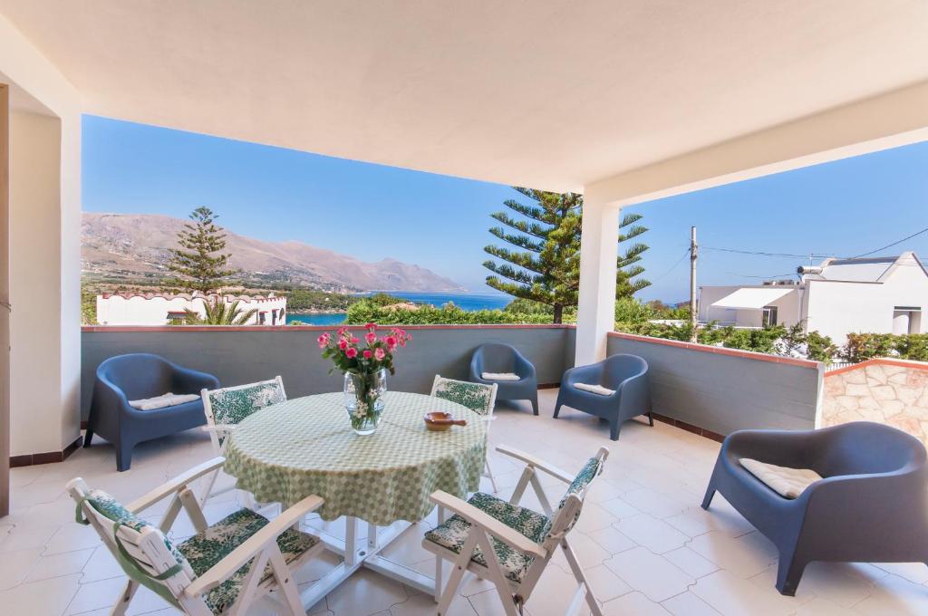 a patio with a table and chairs and a view of the ocean at Villa Saracena in Castellammare del Golfo