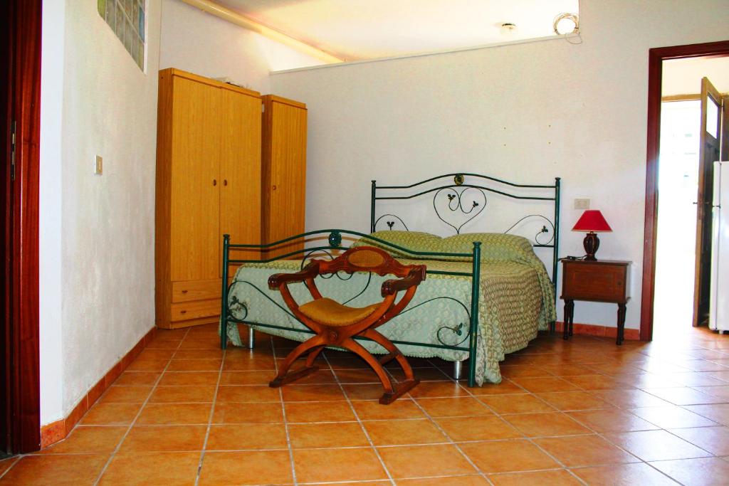 トロペアにあるCasa Vacanze Piaggioのベッドルーム1室(ベッド1台、木製椅子付)