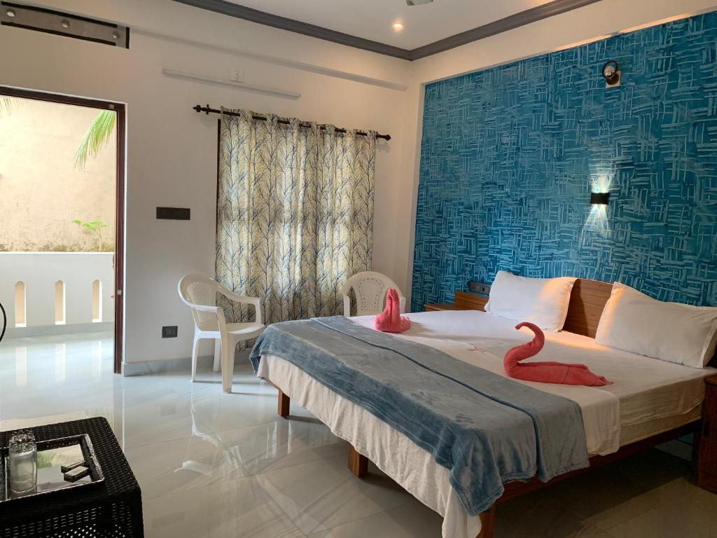 a bedroom with a bed with two pink flamingos on it at Anby Beach resort in Kovalam