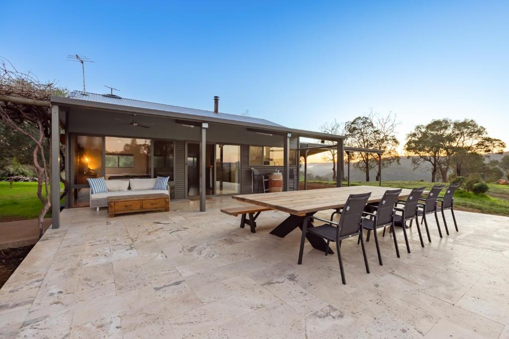 a patio with a wooden table and chairs at Amaroo Swan BnB Management in Perth