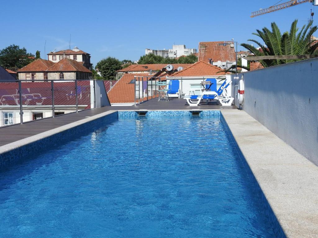 a blue and white swimming pool next to a building at Porto Náutico & Spa in Porto