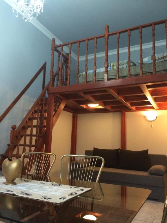 デブレツェンにあるCivis Gold Apartmanのリビングルーム(階段、テーブル、椅子付)