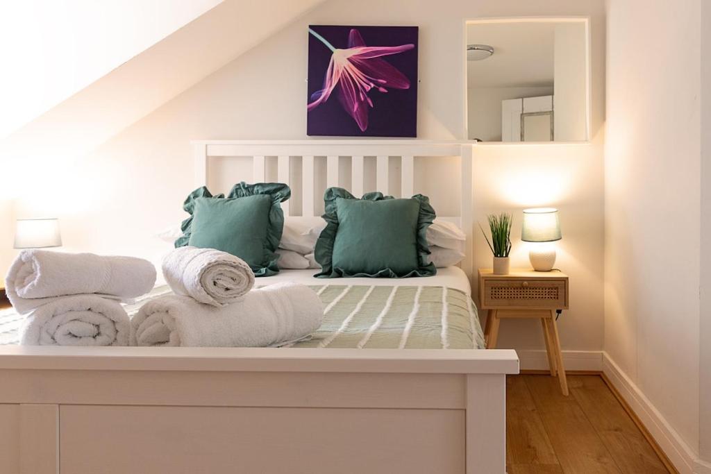 a room with a bed with towels and a mirror at Town Centre Apartment with FREE Parking in Loughborough