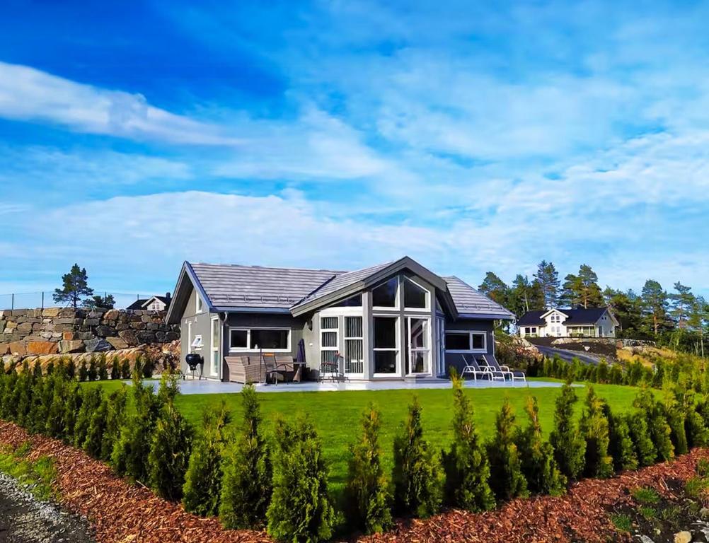 a home with a green yard with a house at Stylish Cabin Experience In Beautiful Surroundings in Færvik