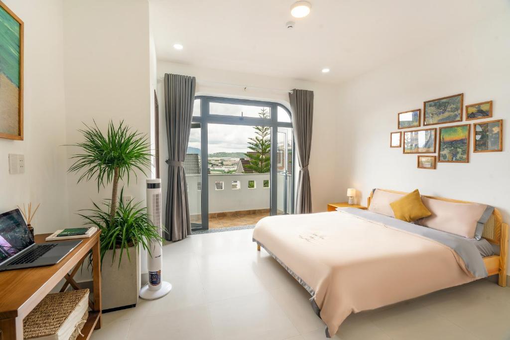 a bedroom with a bed and a desk and a window at Homey Villa in Da Lat