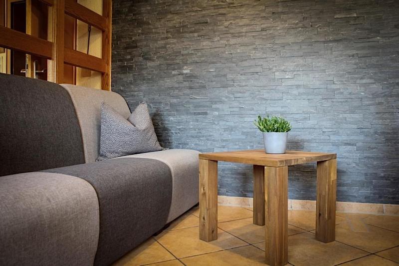 um sofá e uma mesa com um vaso de plantas sobre ele em Hotel Rosenhof Garni em Pegnitz