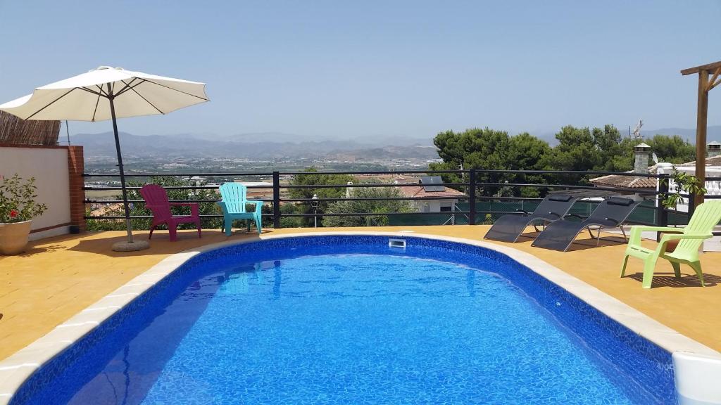 una piscina con sedie e ombrellone su un balcone di Villa Manzanilla, Malaga ad Alhaurín de la Torre
