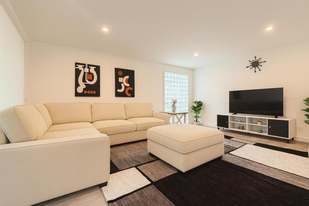 a living room with a couch and a flat screen tv at Santa Monica Beach Retreat with Hot Tub, Billiards & Grill in Los Angeles