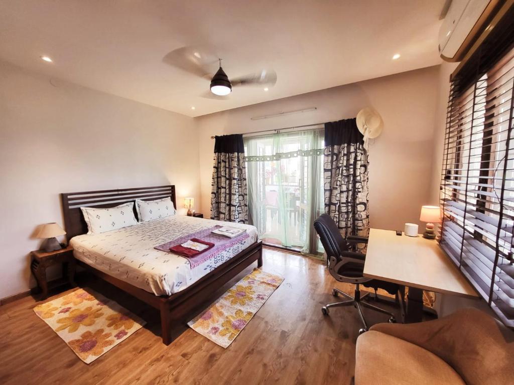 バンガロールにあるRoom lux in the premium apartments Black Orchidのベッドルーム1室(大型ベッド1台、デスク、デスク付)