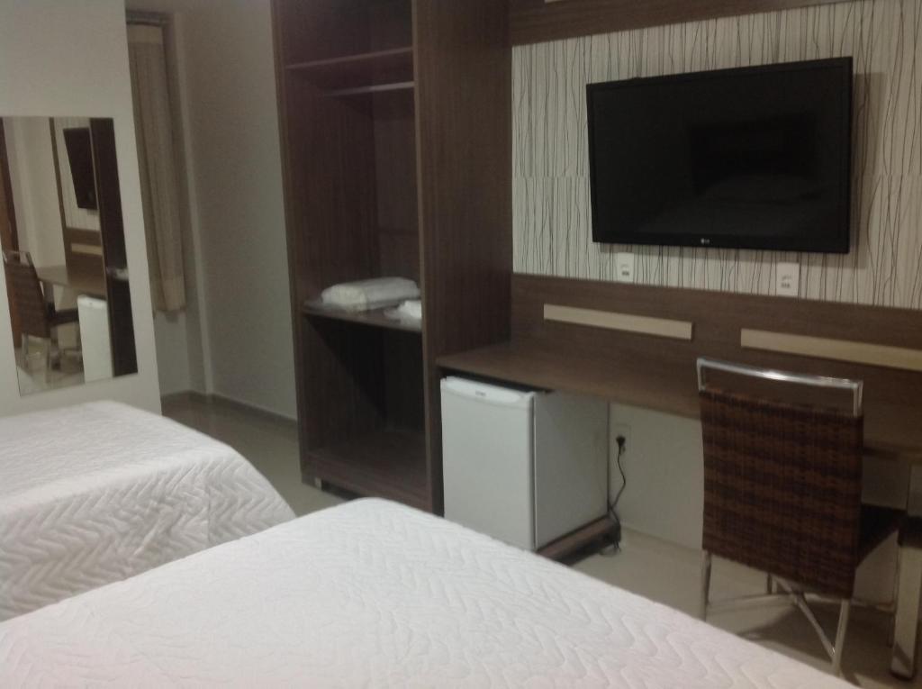 a hotel room with two beds and a television at Rillos Hotel in Altamira