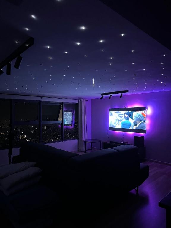 a living room with purple lighting and a tv at Arte Cheras in Kuala Lumpur