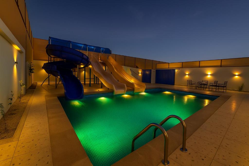 a indoor swimming pool with a slide and a slide slide at Tamyoz Aqama for Serviced Apartments in Hail