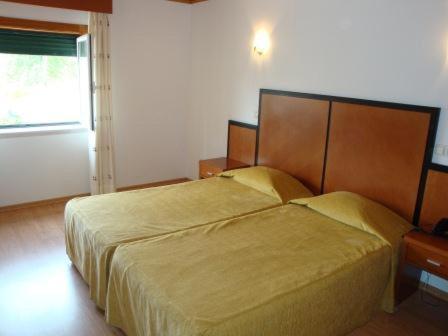 a bedroom with a large bed and a window at Nossa Senhora do Pranto in Ferreira do Zêzere