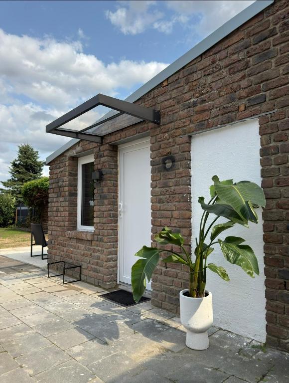 a brick building with two white garage doors and a plant at Comfy House Privé in Erftstadt