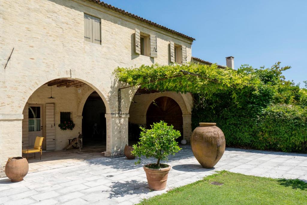 two large vases sitting in front of a building at a 15 min da Venezia App Rustico moderno-Treviso in Villa Cameroni