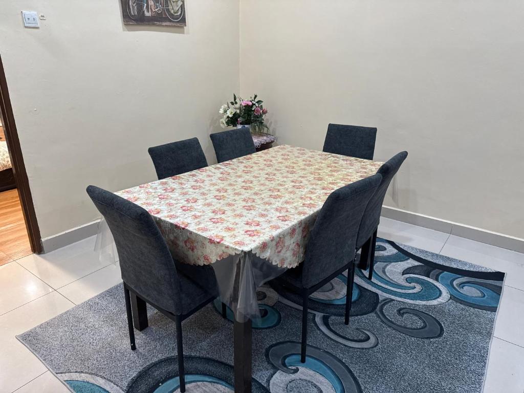 a dining room table with four chairs around it at Utaqha Ventures Homestay in Seri Manjung