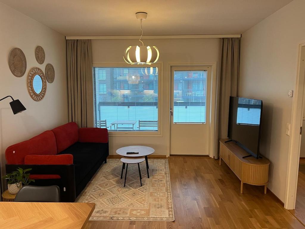 a living room with a couch and a tv at Quality dreams - modern two-room apartment - private parking in Turku