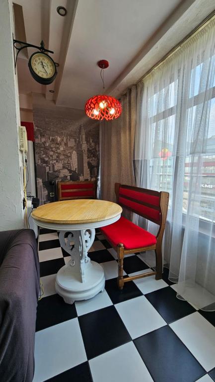 a room with a table and two chairs and a clock at Apartment on Nazarbayeva 77 in Almaty