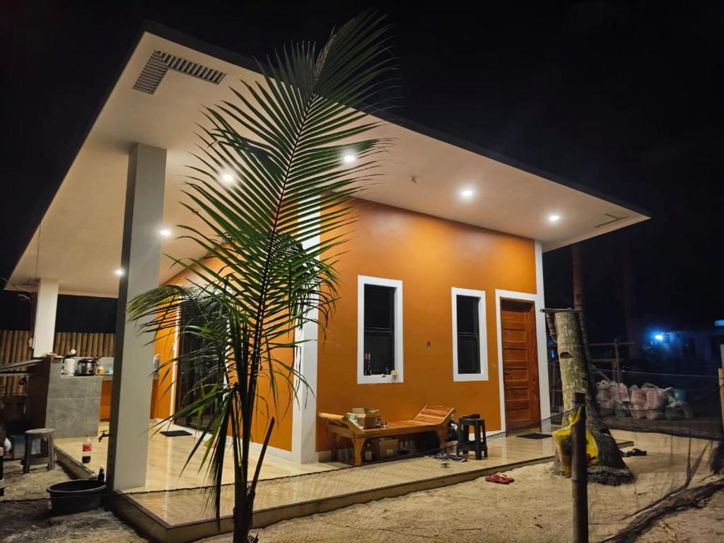 a small house with a palm tree in front of it at Orange House in San Juan