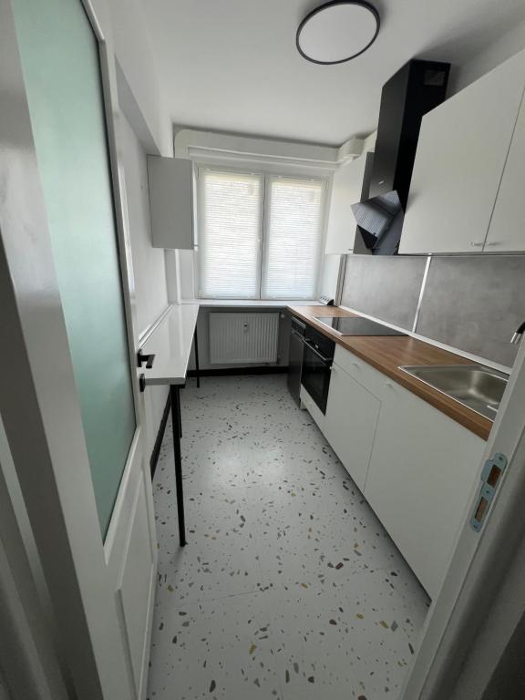 a small kitchen with white cabinets and a sink at Alma Residence Amzei in Văleni