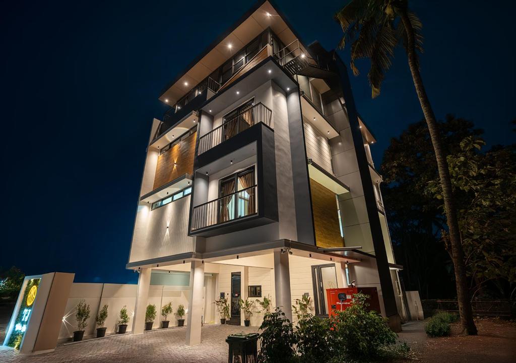 a tall building with a night view of it at TJ VISTA LIVING in Edappally