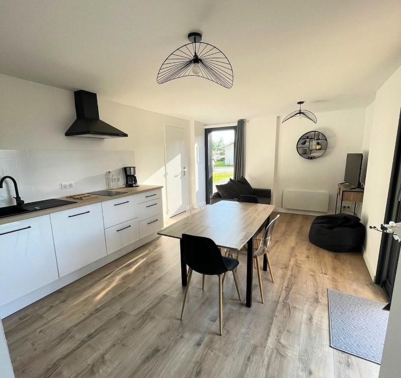 a kitchen and dining room with a table and chairs at la pause landaise in Saint-Vincent-de-Paul