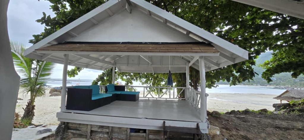 a gazebo with a couch on the beach at Beach House in Chaloklum