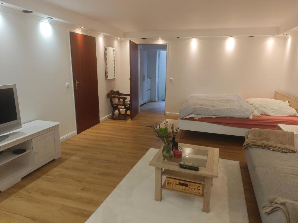 a living room with a bed and a couch at Ruhige FeWo Soutterainwohnung im Grünen in Hamburg