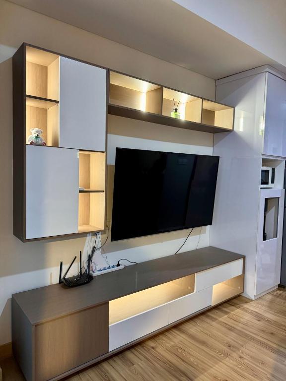 ein Wohnzimmer mit einem Flachbildfernseher an der Wand in der Unterkunft Luxury Apt in South Jakarta in Jakarta