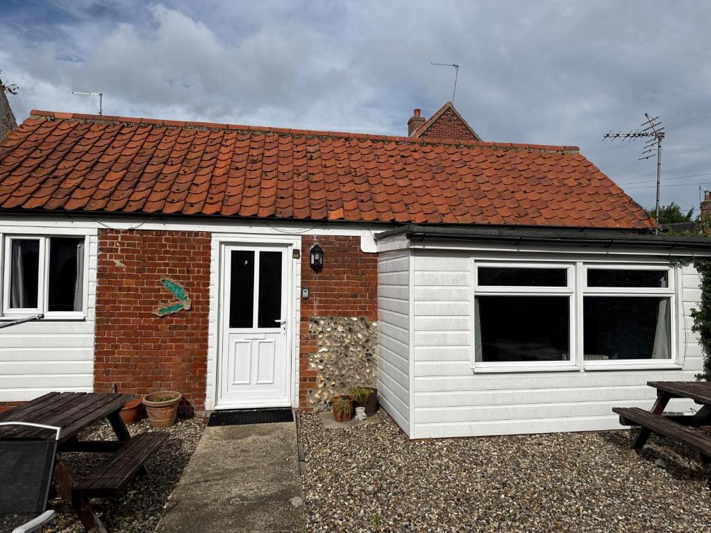 a small white shed with a red roof at Holly cottage in Catfield