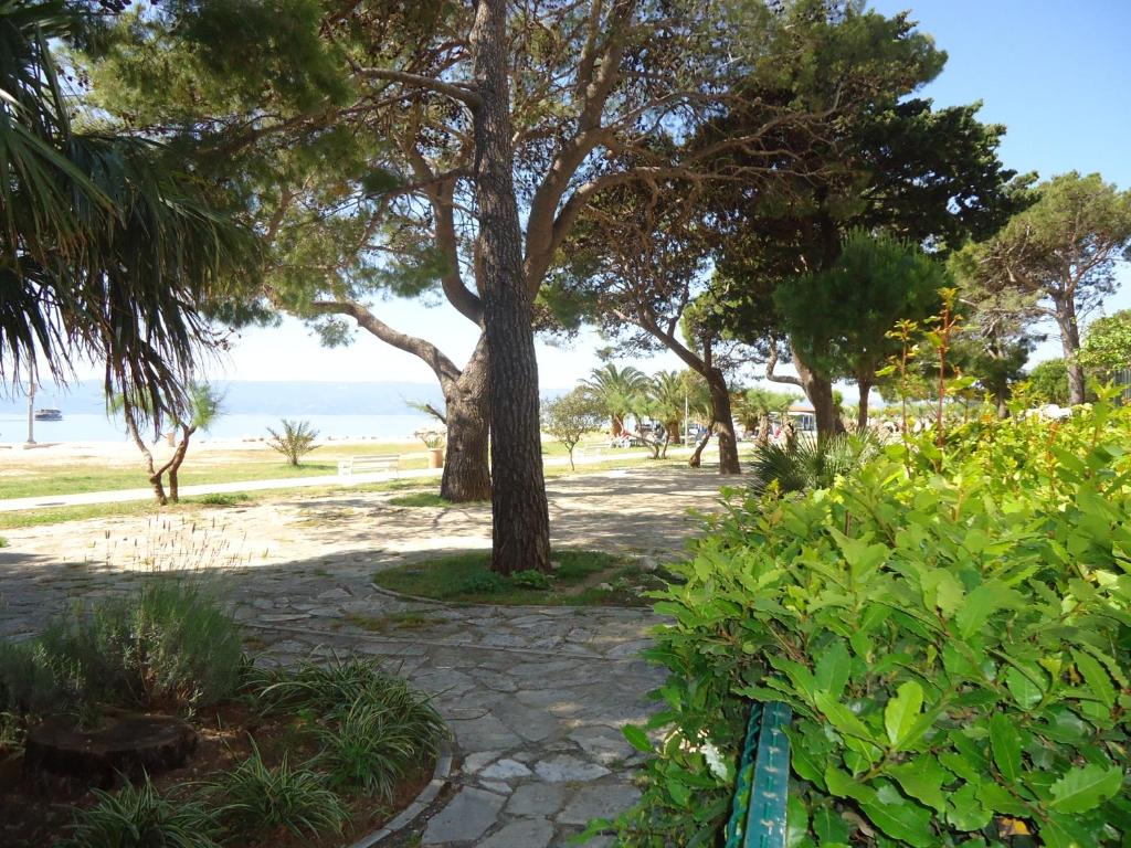 a park with a bench and trees and the beach at Omiš apartment on the beach in Omiš