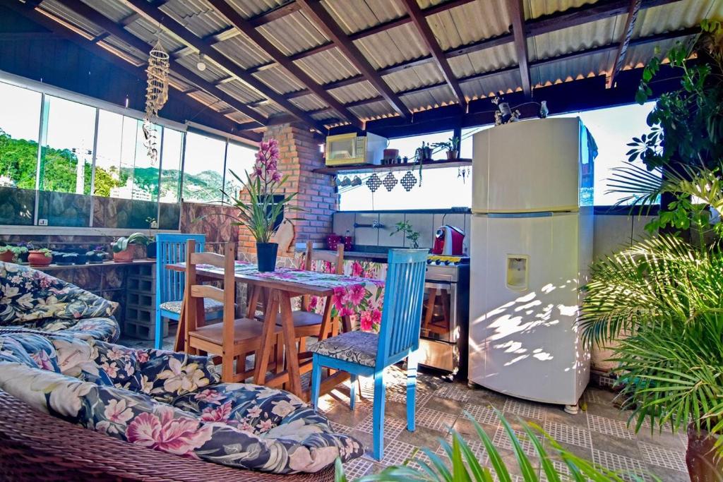Una cocina con refrigerador y una mesa con sillas. en Floripa espaço independente com próx Centro e UFSC, en Florianópolis