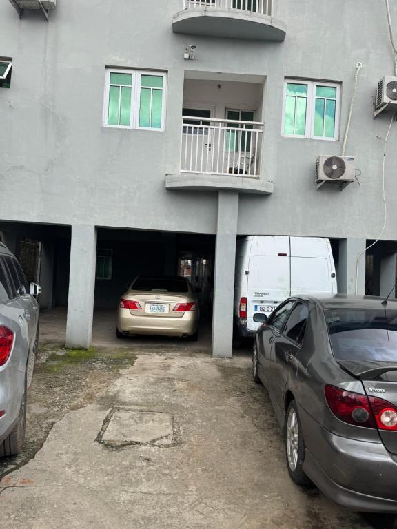 a parking lot with cars parked in front of a building at Home feel in Ikeja