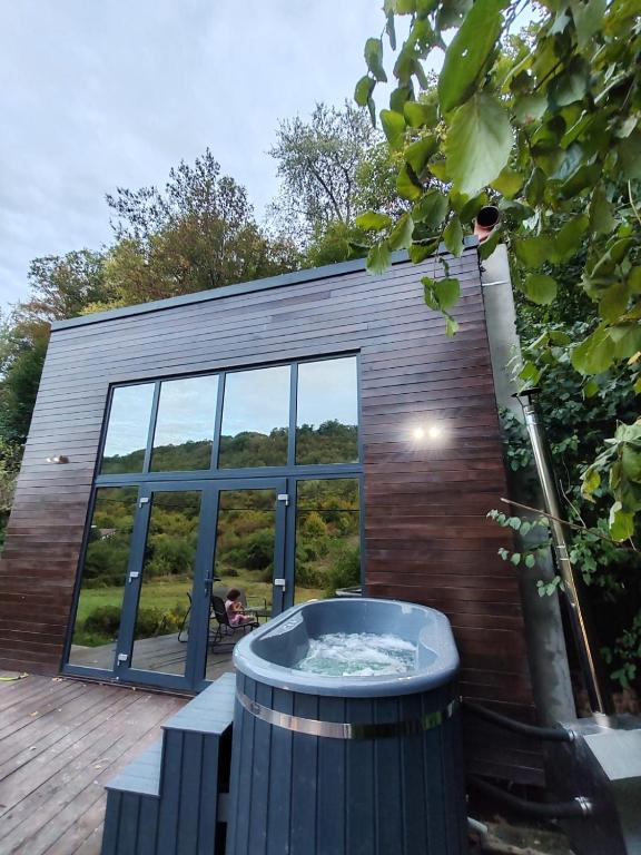 a building with a hot tub on a deck at Forest Studio Corunca in Corunca