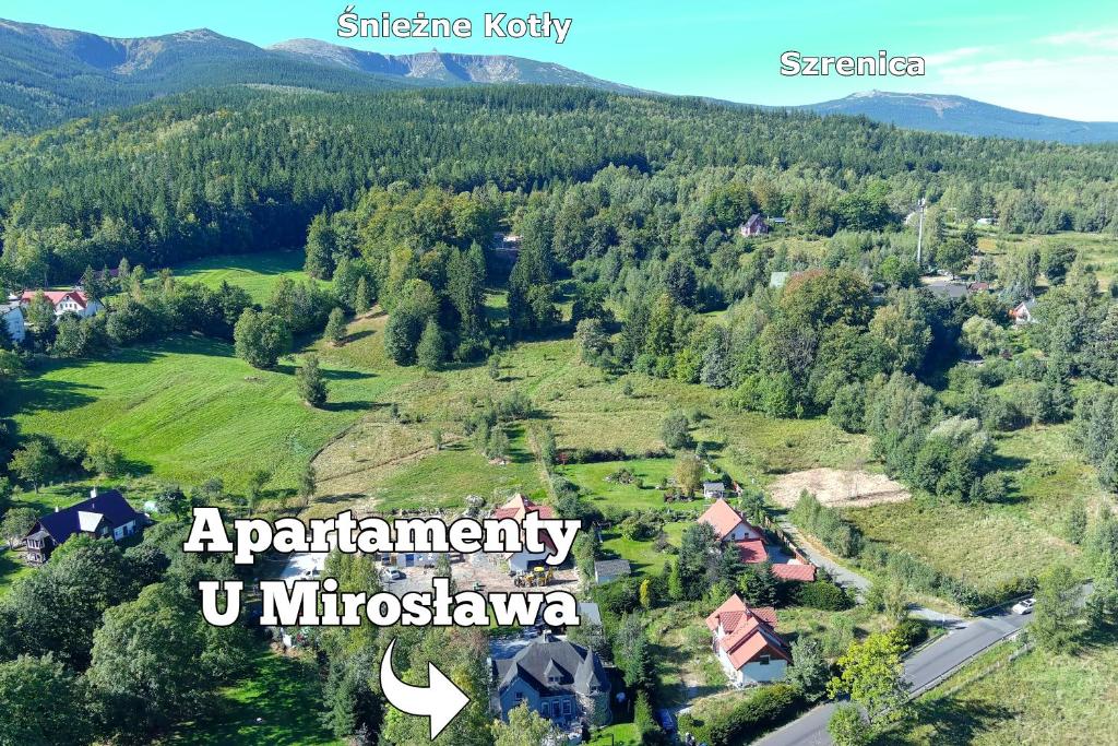 une vue aérienne sur un petit village dans une forêt dans l'établissement Apartamenty Karkonosze U Mirosława - JAGNIĄTKÓW, à Jelenia Góra