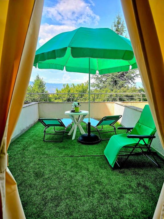 a patio with a table and chairs and an umbrella at Apartment - Studio Cucetno in Sandanski
