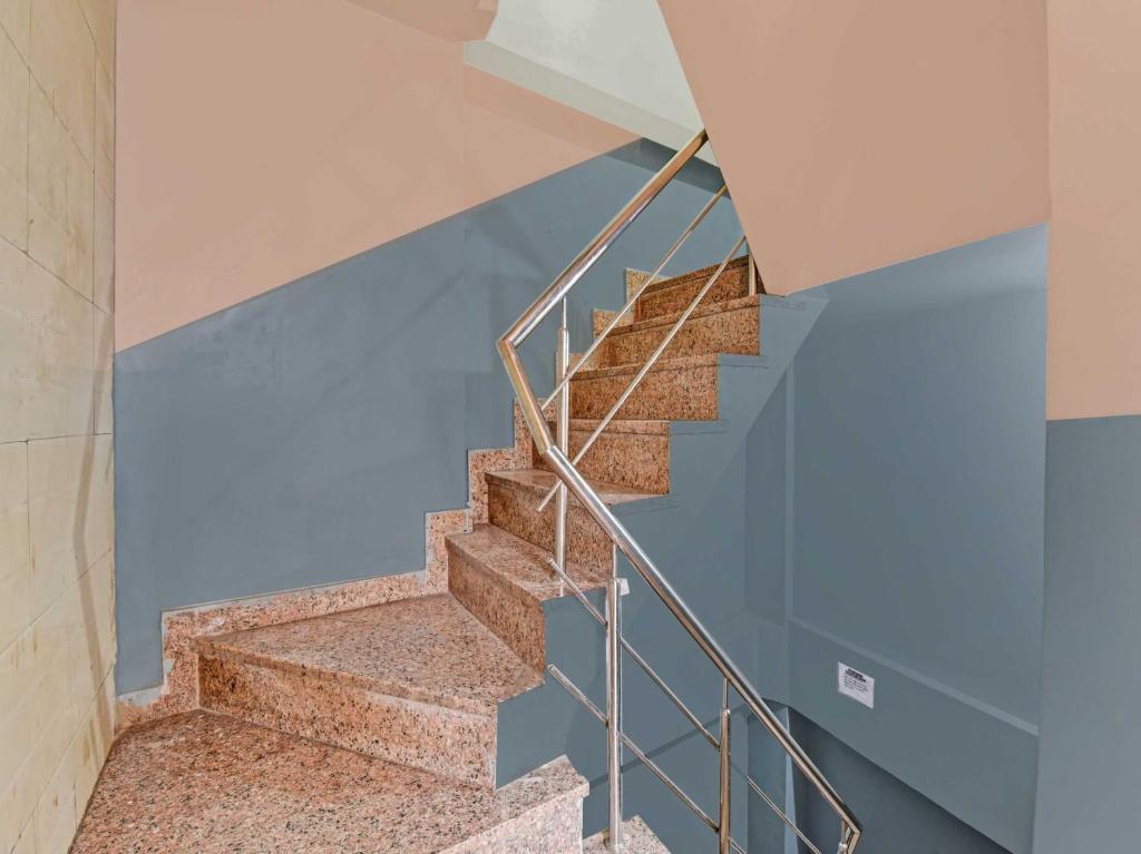 アジメールにあるOYO 85212 Hotel Vaibhavの鉄製の手すりと青い壁の階段
