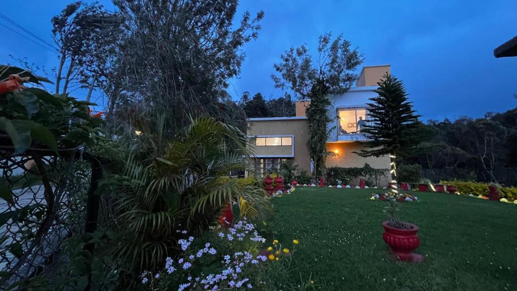 a house with a yard with flowers and plants at Willostays Cluster Clouds in Ooty