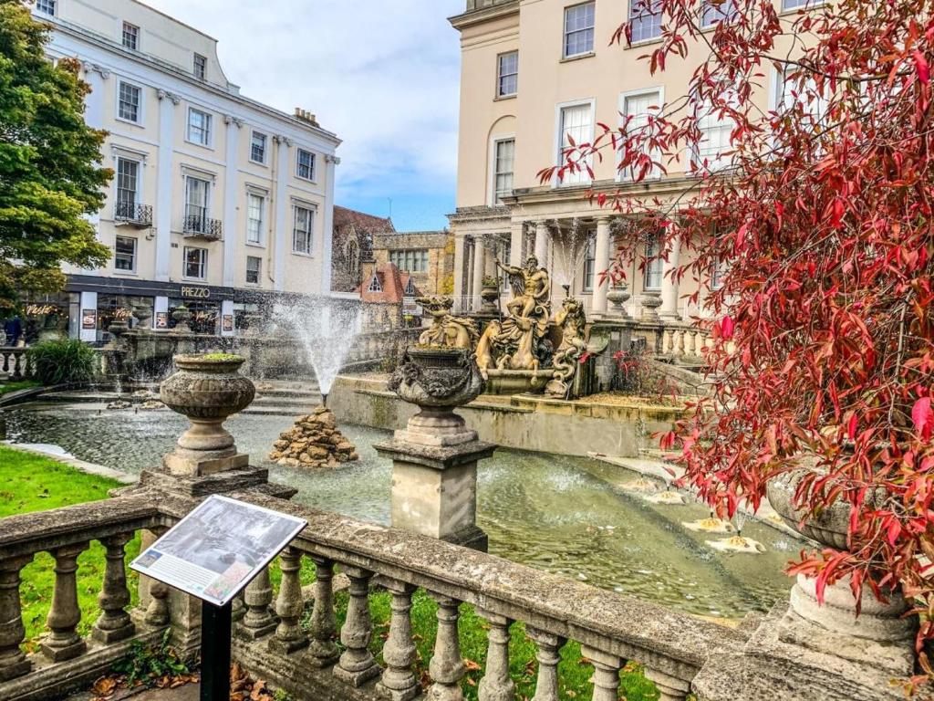 a fountain in the middle of a city with buildings at Luxury Woodland Stay in Cheltenham in Cheltenham
